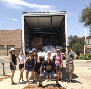 Volunteers standing in front of truck full of donated clothing.
